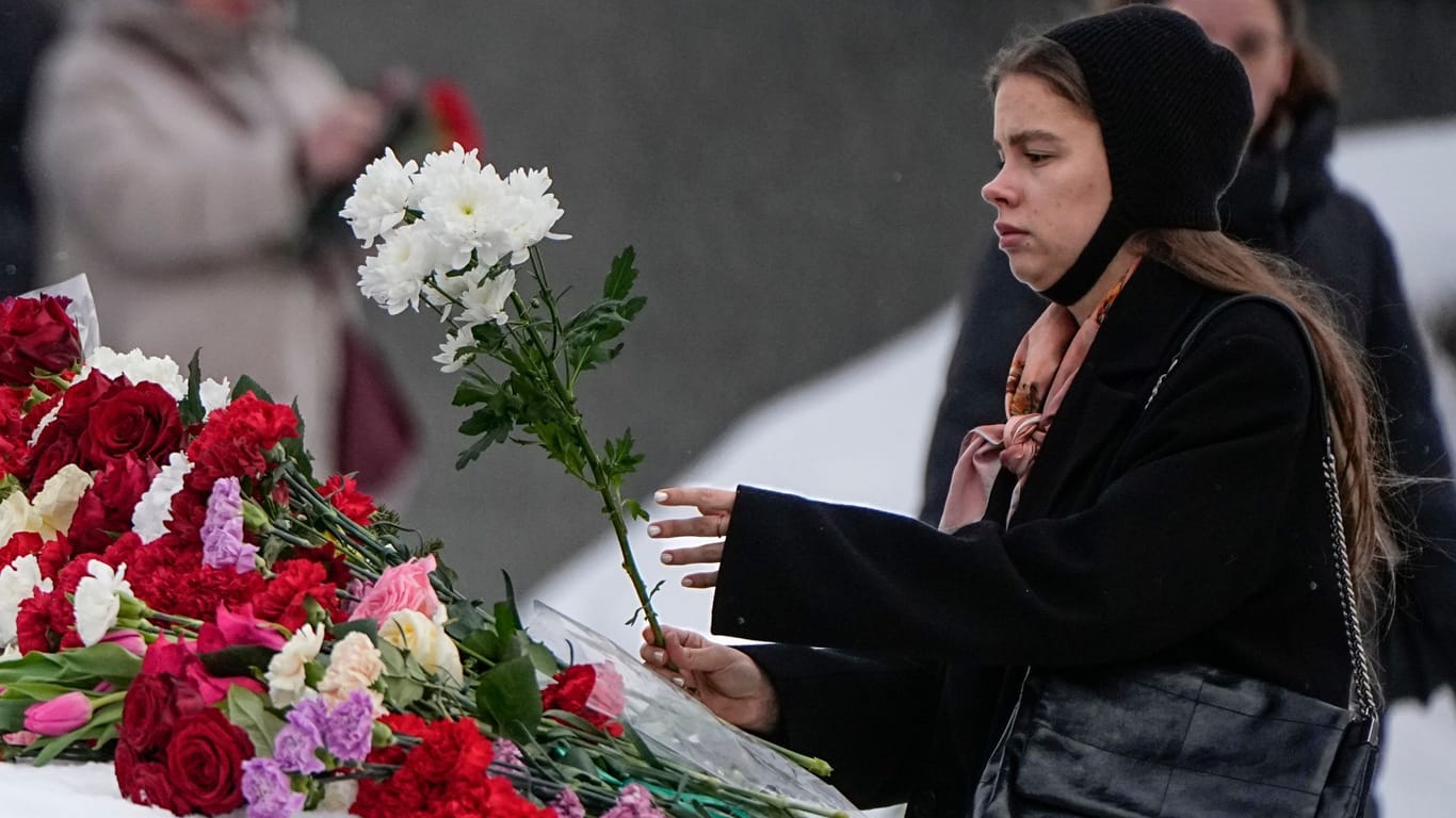 Eine Frau legt in Russland Blumen nieder, um Nawalny die letzte Ehre zu erweisen (Archivbild): Auf diese Geste steht in Russland eine Strafe.