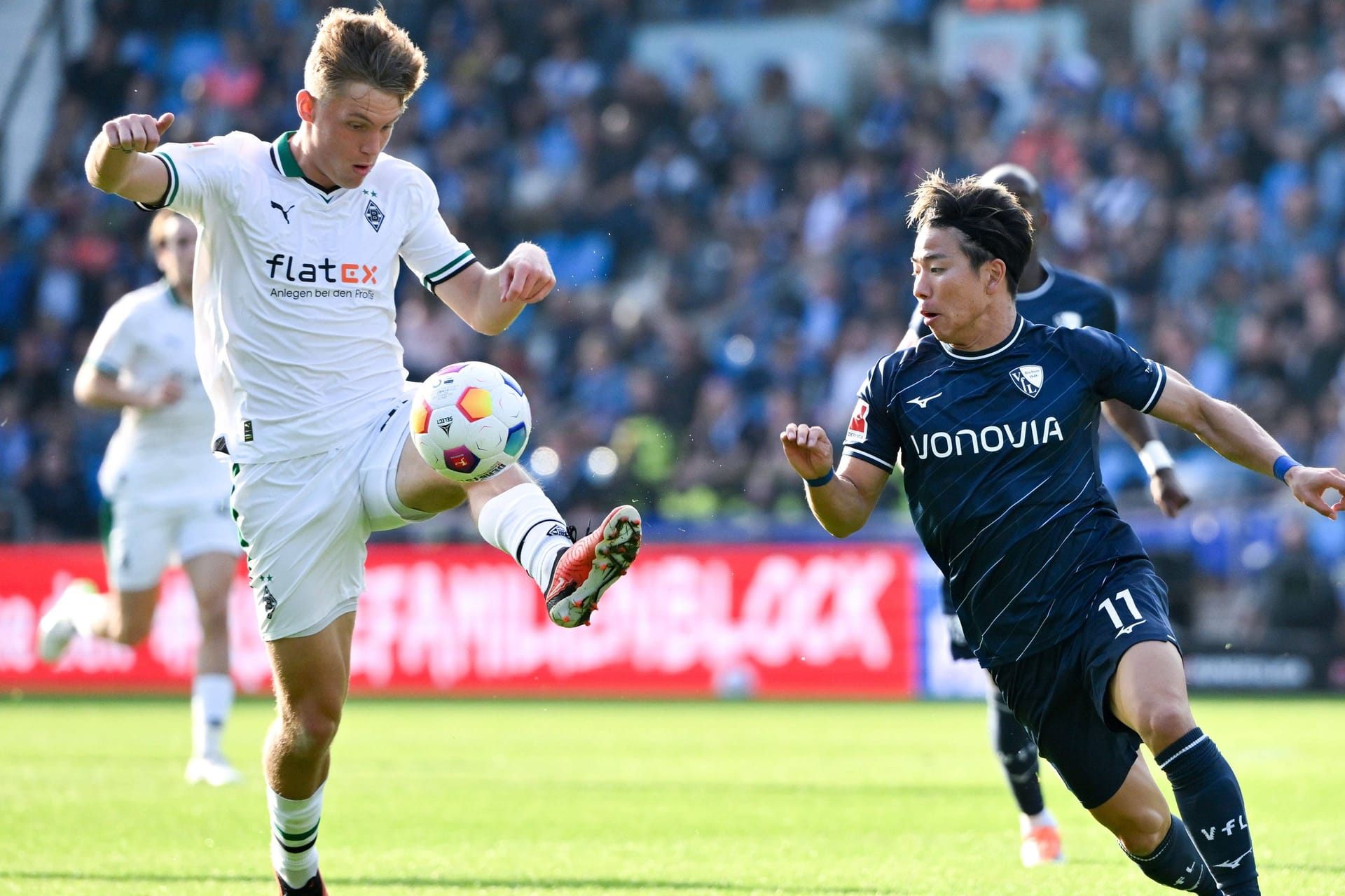 Gladbachs Luca Netz (l.) im Duell mit dem Bochumer Takuma Asano im Hinspiel: Die Partie im Borussia-Park hat etwas Verspätung.