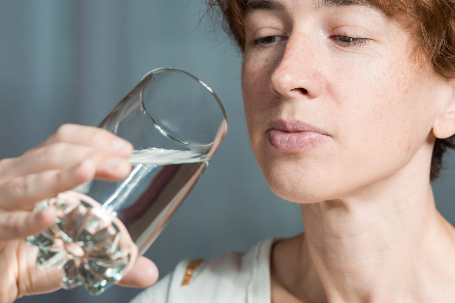 Eine Frau betrachtet ein Glas Wasser