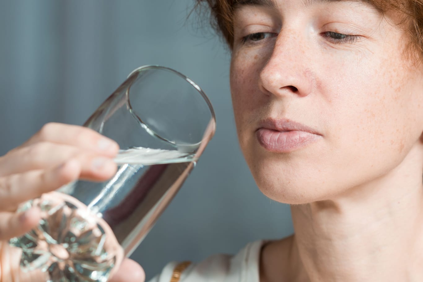 Eine Frau betrachtet ein Glas Wasser