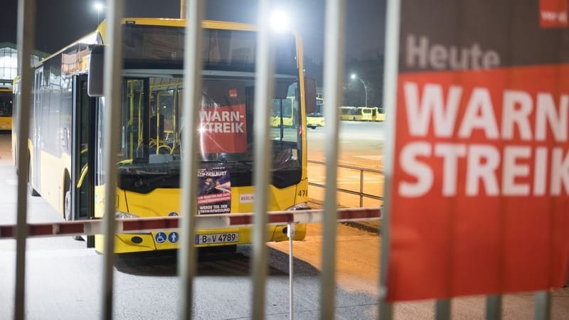 ARCHIV - Ein Schild mit der Aufschrift «Warnstreik» hängt an einem Busdepot der BVG