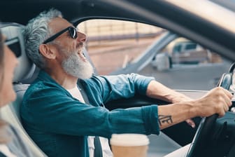 Älterer Autofahrer und Beifahrerin lachen