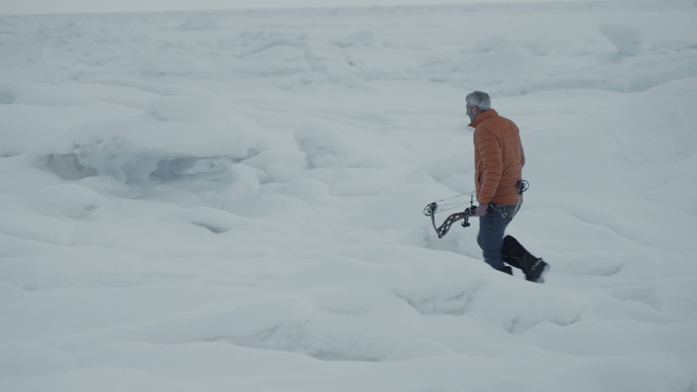 Michel Abdollahi geht mit Pfeil und Bogen durch eine Schneelandschaft: In Kanada ist Eisbärenjagd legal.