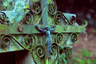 Grabkreuz mit Christusfigur: In Bayern sitzen zwei Männer für Metalldiebstähle auf Friedhöfen in Untersuchungshaft.