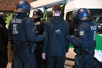 Polizisten halten einen HSV-Fan fest: Nach einer Kontrollaktion in Bergedorf gibt es harte Kritik am Vorgehen.