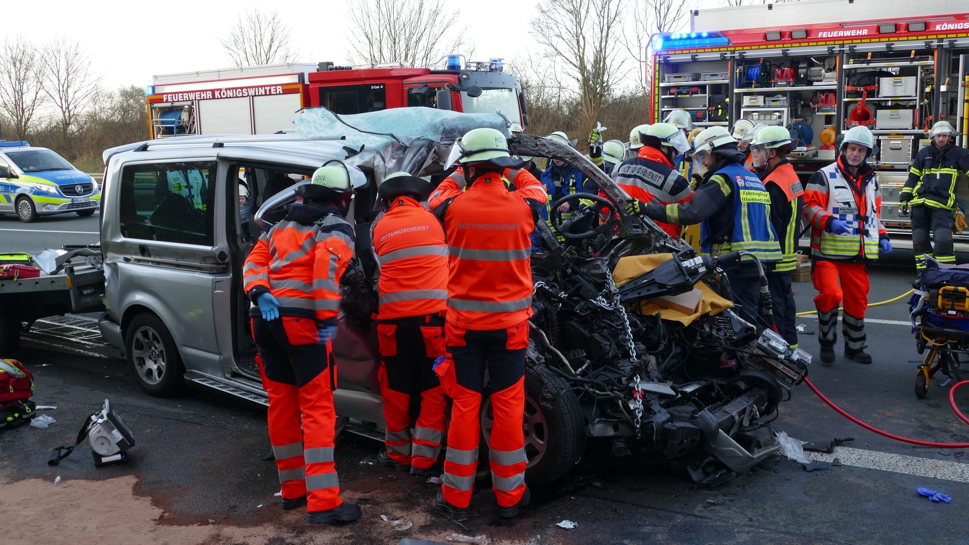 Feuerwehrleute befreiten eine Person aus dem komplett demolierten Wagen.