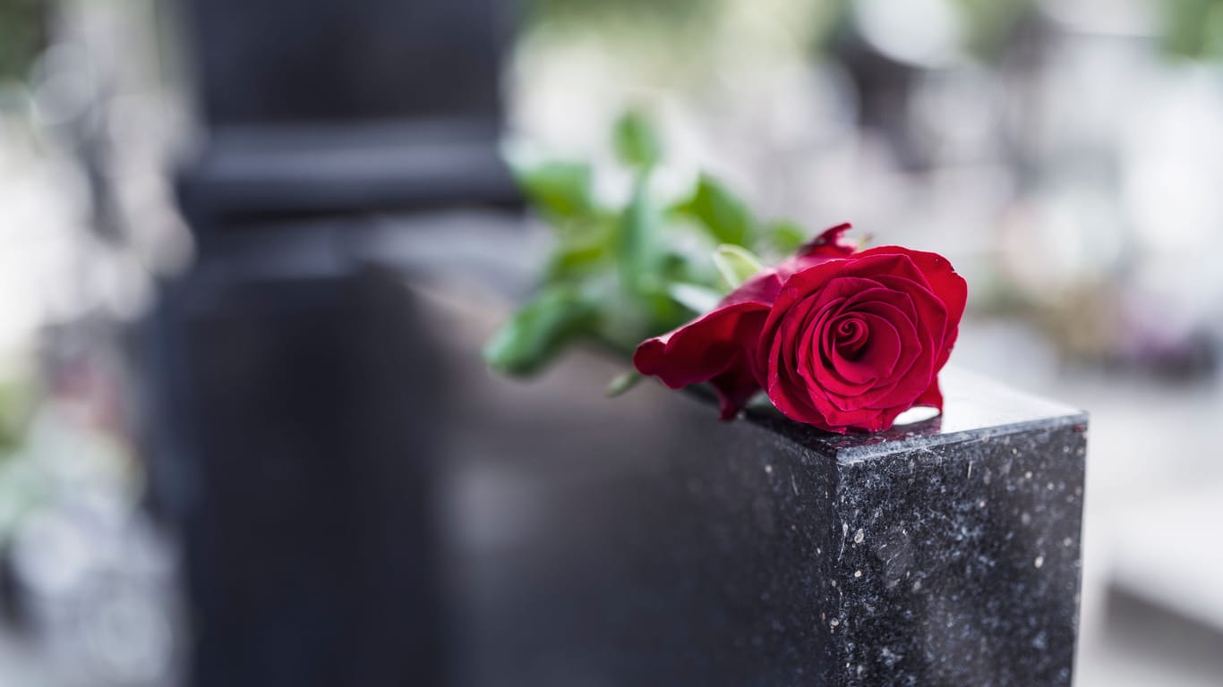 Eine Rose liegt auf einem Grabstein (Symbolbild): Ein Sozialpädagoge wurde im Januar Opfer eines Raubmordes.