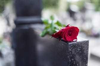 Eine Rose liegt auf einem Grabstein (Symbolbild): Ein Sozialpädagoge wurde im Januar Opfer eines Raubmordes.
