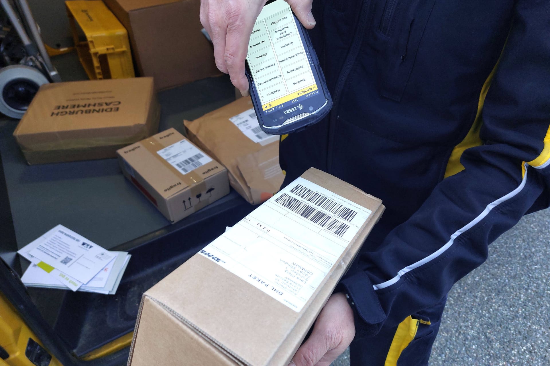 Ein Paketbote registriert ein Paket (Symbolbild): In Düsseldorf wurde einem Zusteller mit dem Tod gedroht.