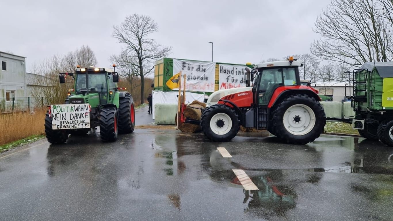 Landwirte blockieren eine Zufahrt zum Industriegebiet in Brunsbüttel: Die Polizei ist zum Gespräch vor Ort.