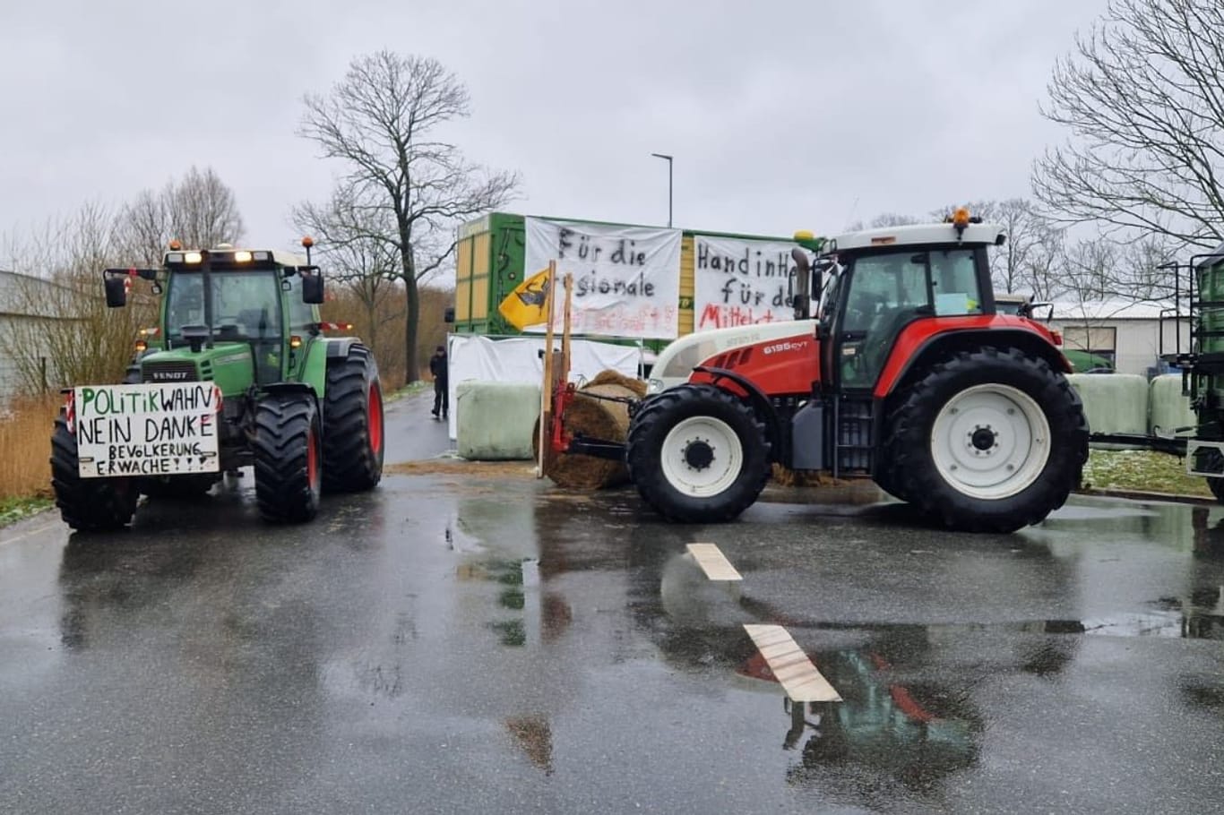 Landwirte blockieren eine Zufahrt zum Industriegebiet in Brunsbüttel: Die Polizei ist zum Gespräch vor Ort.