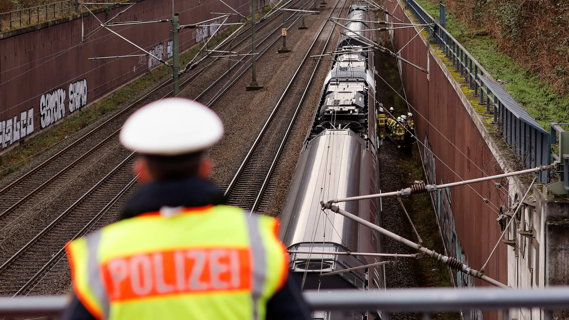 Ein Polizeibeamter schaut auf Bahngleise (Symbolbild): Im September kam ein Bahnmitarbeiter in Kalk ums Leben. Ein Polizeibeamter schaut auf Bahngleise (Symbolbild): Im September kam ein Bahnmitarbeiter in Kalk ums Leben.