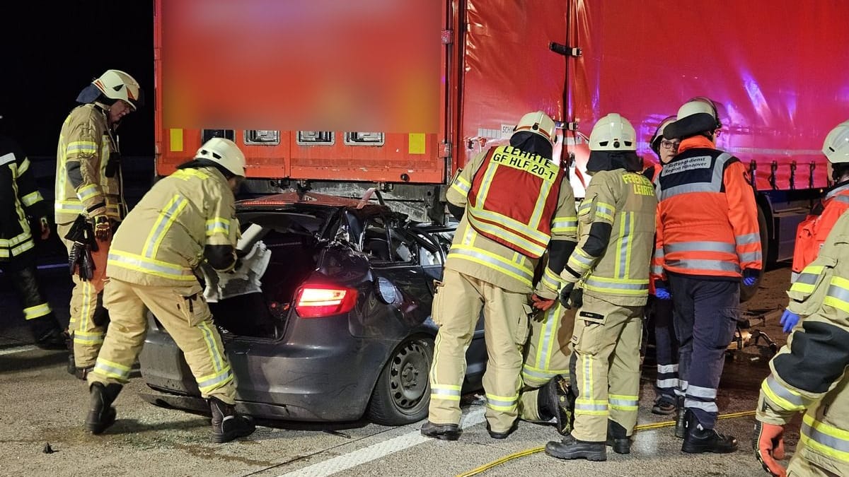 Einsatzkräfte der Feuerwehr an der Unfallstelle: Der Wagen geriet fast vollständig unter den Sattelzug. Einsatzkräfte der Feuerwehr an der Unfallstelle: Der Wagen geriet fast vollständig unter den Sattelzug.
