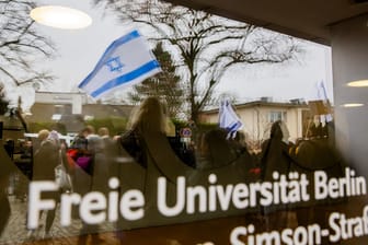 Eine Israel-Flagge spiegelt sich bei einem stillen Protest einer Initiative für die Sicherheit jüdischer Studierender: Die Demo fand an der Freien Universität Berlin statt.