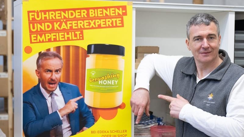 Imker Rico Heinzig neben einem Plakat mit dem Foto des Moderators Jan Böhmermann: