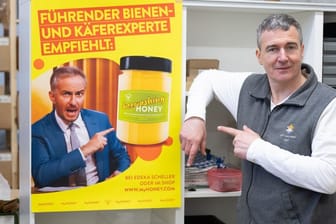 Imker Rico Heinzig neben einem Plakat mit dem Foto des Moderators Jan Böhmermann:
