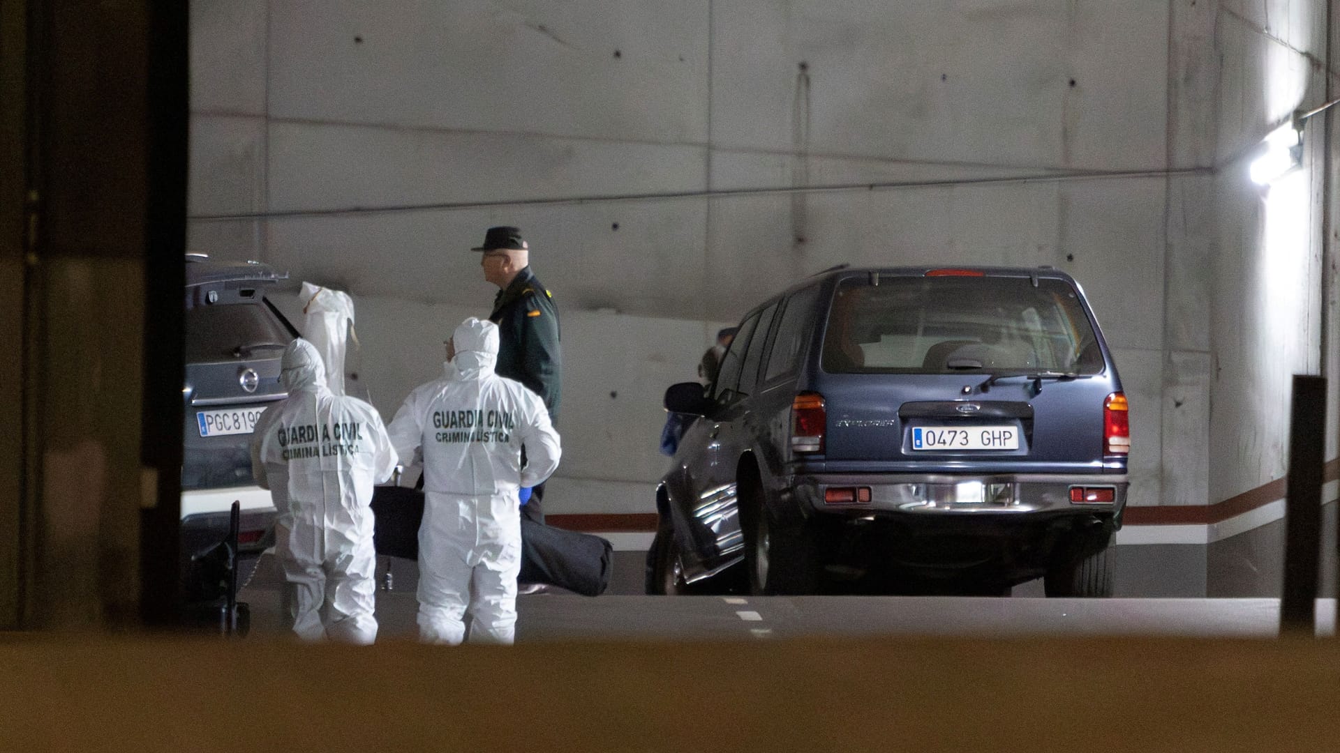 Spanische Ermittler durchsuchen den Tatort in einer Tiefgarage in einem Apartmenthaus.