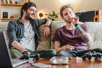 Zwei Männer rauchen einen Joint