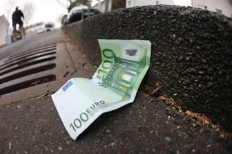 Ein 100-Euro-Schein liegt auf der Straße (Symbolbild): In München und anderen Städten verstecken Unbekannte derzeit immer wieder Geld.