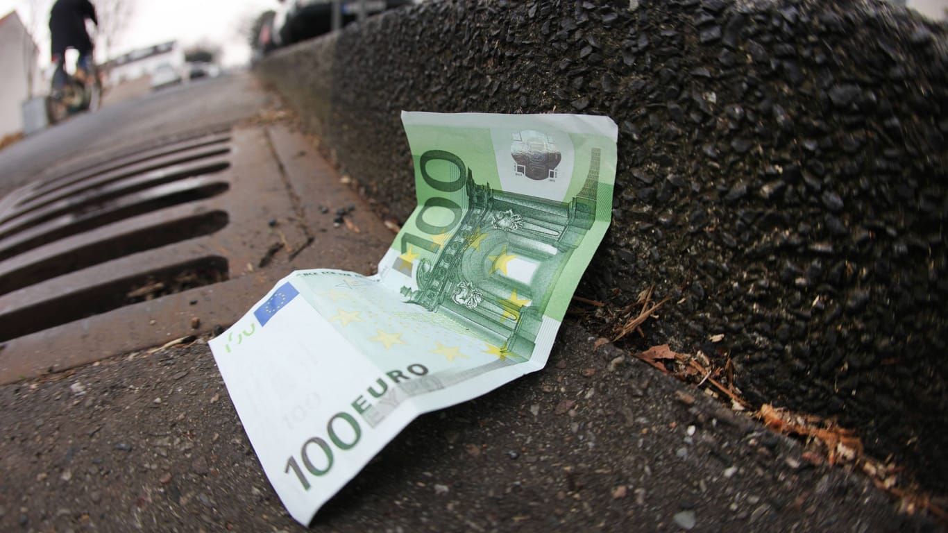Ein 100-Euro-Schein liegt auf der Straße (Symbolbild): In München und anderen Städten verstecken Unbekannte derzeit immer wieder Geld.