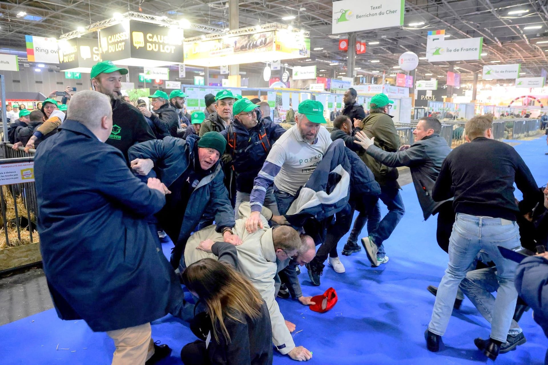 24.02.2024, Frankreich, Paris: Landwirte raufen mit dem Sicherheitspersonal auf der Internationalen Landwirtschaftsmesse, während der französische Präsident Macron die Ausstellung am Eröffnungstag besucht. Landwirte in ganz Europa protestieren seit Wochen gegen die ihrer Meinung nach übermäßig restriktiven Umweltvorschriften. Foto: Ludovic Marin/AFP Pool/AP/dpa +++ dpa-Bildfunk +++