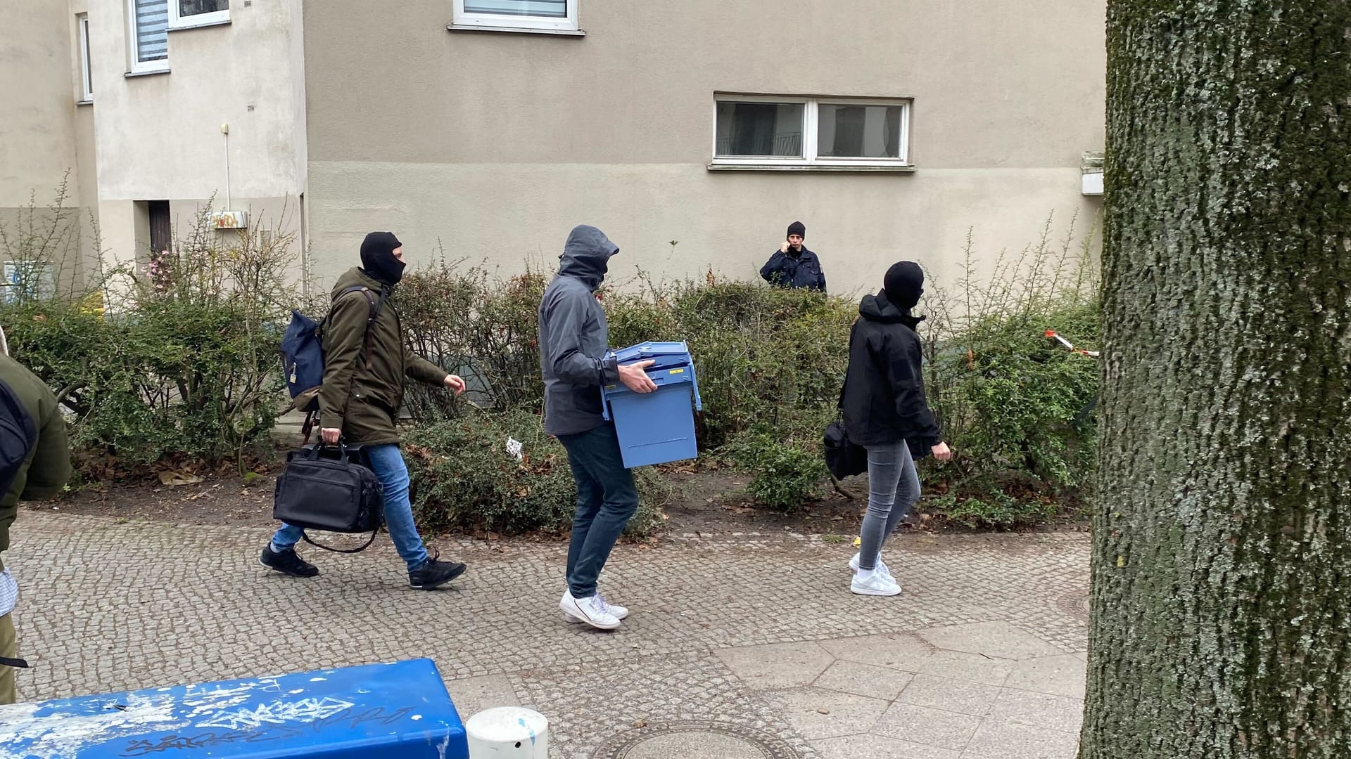 Vermummte Polizisten mit Behältnissen: Am Morgen sind viele Beamte in der Sebastianstraße.