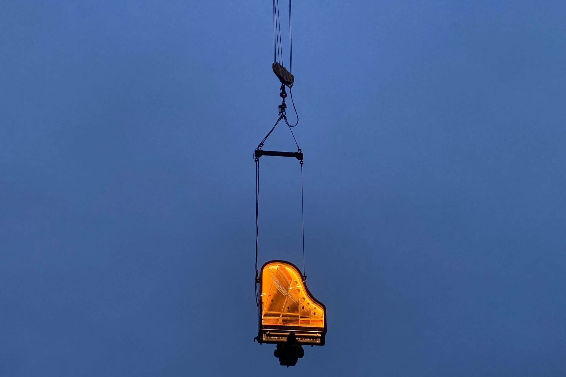 Während der Blauen Stunde, also dem Zeitraum kurz vor dem Sonnenaufgang, spielt der Künstler Alain Roche in zehn Metern Höhe auf seinem Klavier. Beide hängen dabei vertikal an einem Kran.