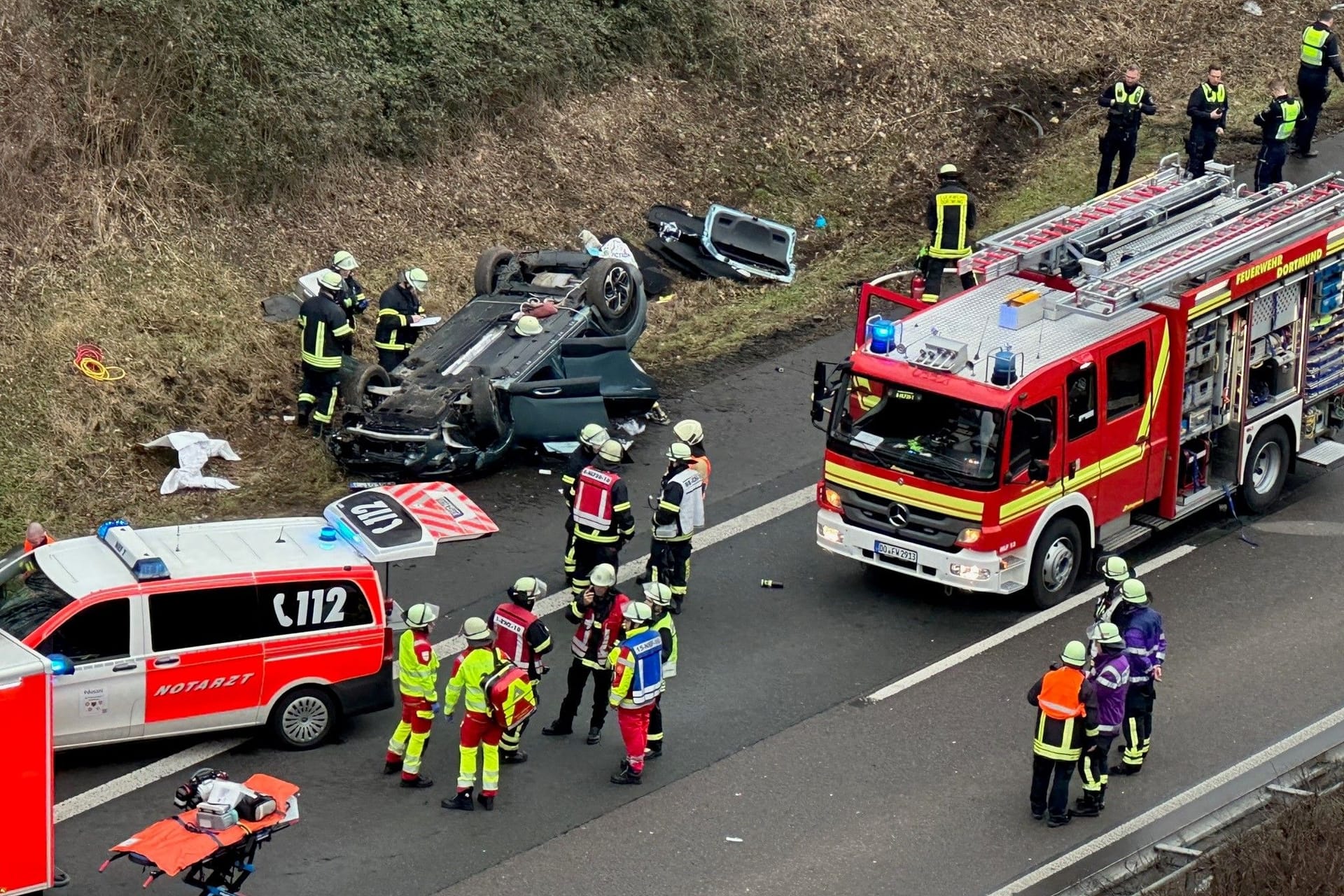 Schwerer Unfall auf der A45 bei Dortmund: Ein Pkw hat sich offenbar überschlagen und ist auf dem Dach liegend auf dem Grünstreifen zu sehen.