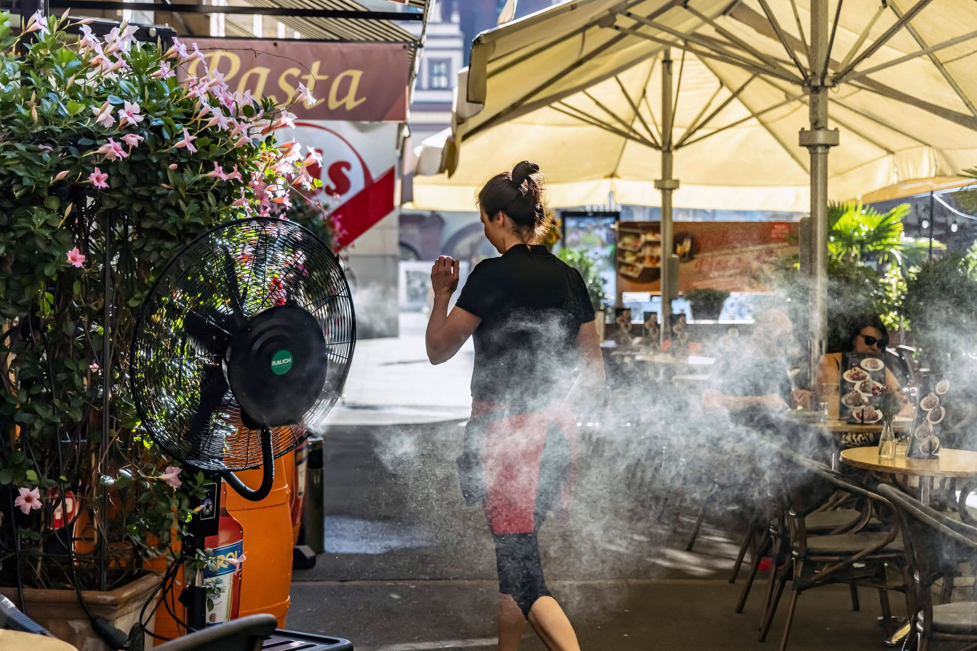 Leipzig (Archivbild): Ein Im Straßencafé wird mit Ventilatoren und Wasserdampf gekühlt.