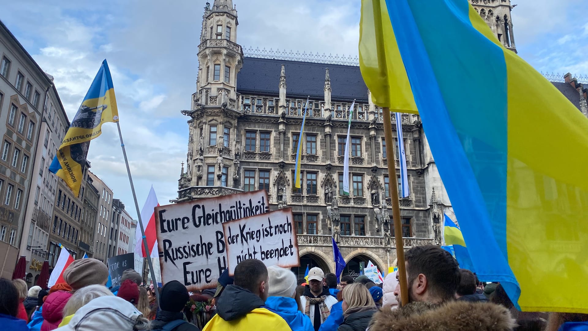 "Der Krieg ist noch nicht beendet", heißt es auf einem der Schilder, die bei der Demo am Marienplatz in München.