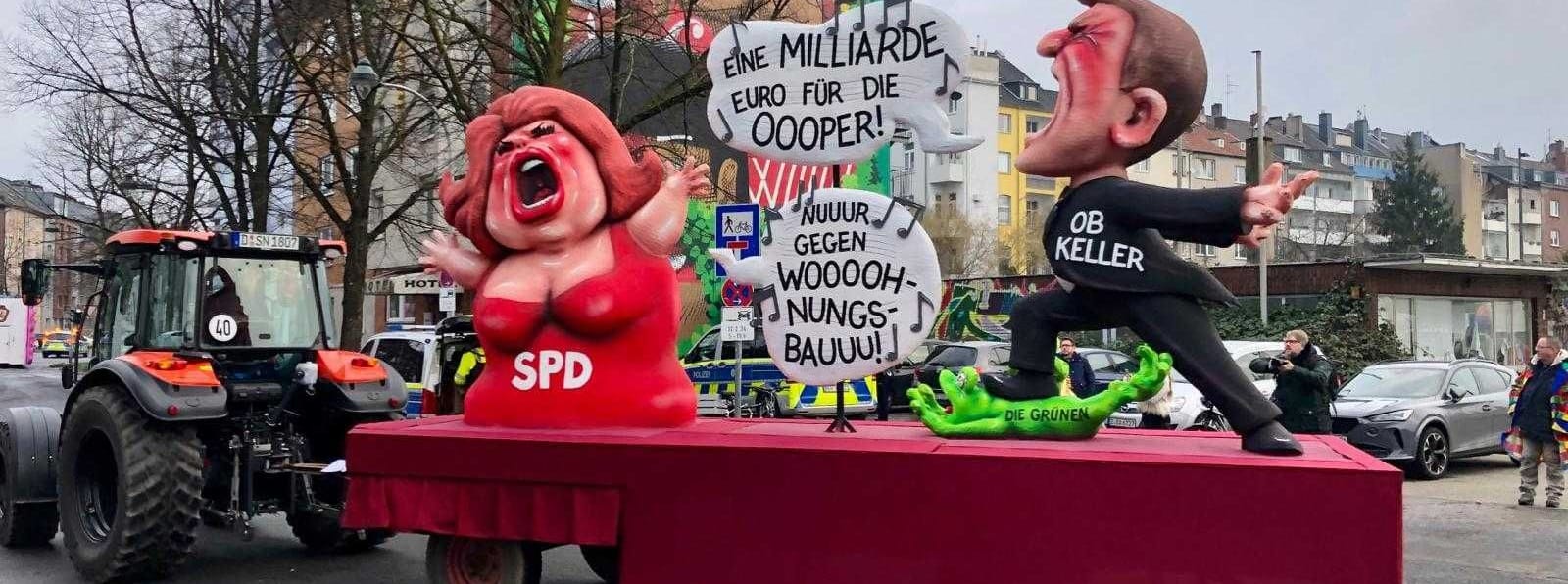 Die Lokalpolitik thematisiert Jacques Tilly auf einem seiner Wagen ebenfalls. Zu sehen ist Oberbürgermeister Stephan Keller (CDU), der für eine teure neue Oper wirbt. Die SPD entgegnet ihm: "Nuuur gegen Woooohnungsbauuu!"