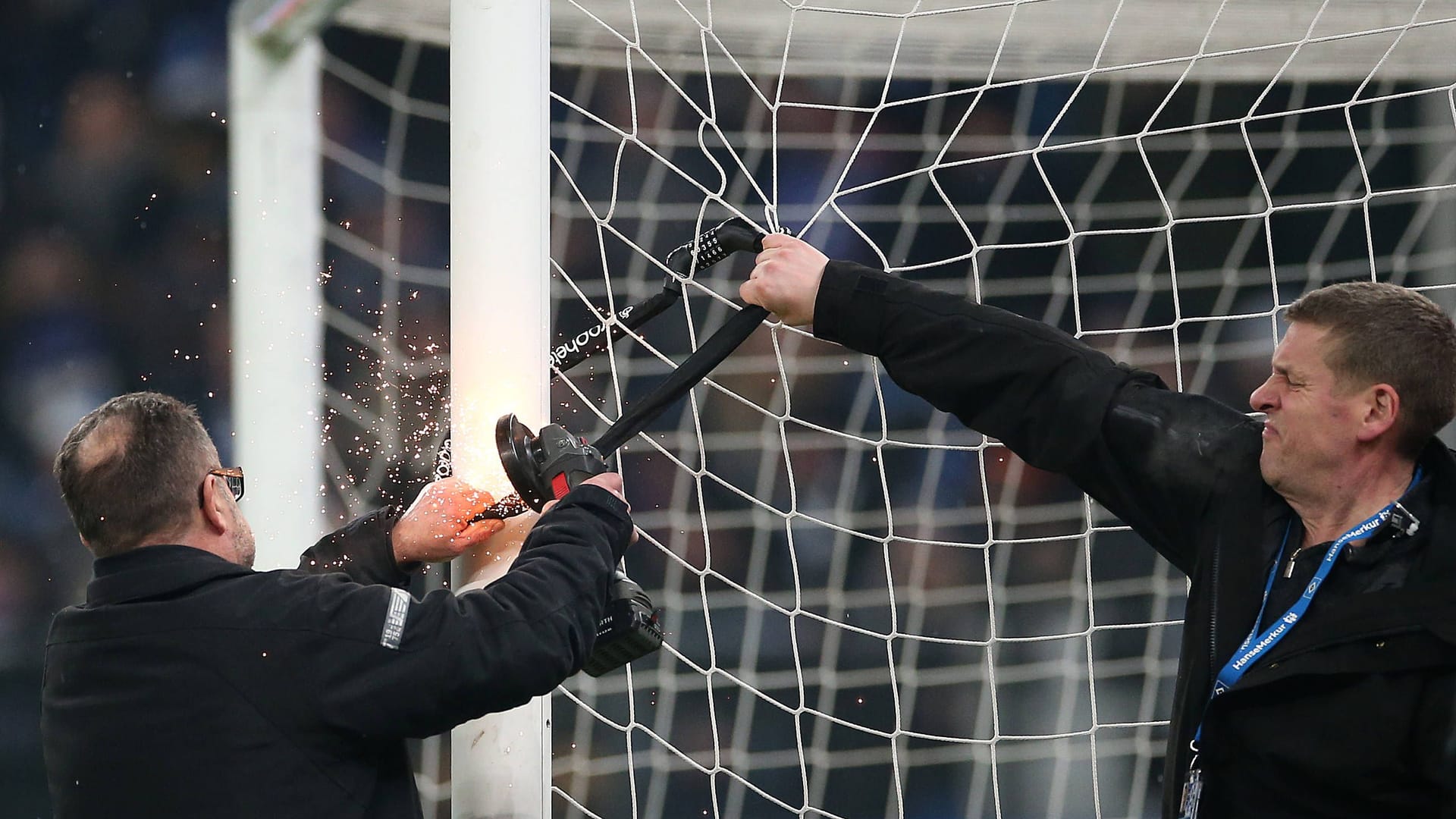 Experten entfernen ein Fahrradschloss am Tor beim HSV-Spiel gegen Hannover 96: Den Ultras ist ein Etappensieg gelungen.