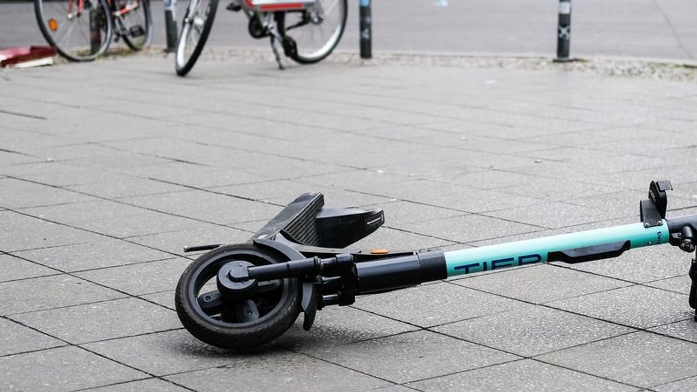 Ein E-Scooter liegt umgekippt mitten auf dem Gehweg in Berlin-Friedrichshain