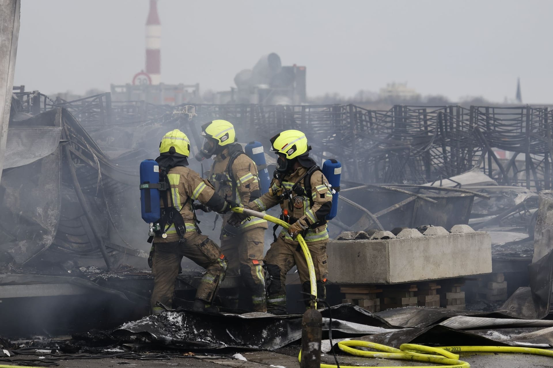 Die Feuerwehr löscht die Brandstelle bei Flüchtlingsunterkunft am ehemaligen Flughafen Tegel: Ein Zelt stand hier im Brand.