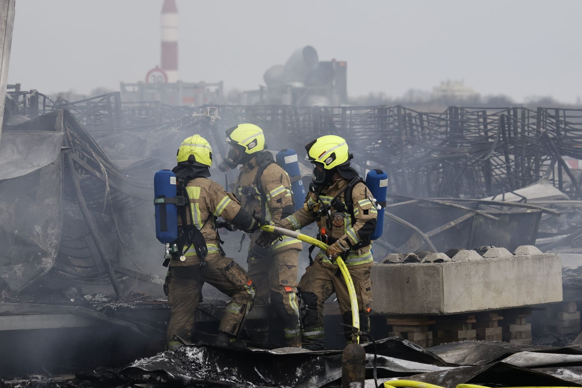 Die Feuerwehr löscht die Brandstelle bei Flüchtlingsunterkunft am ehemaligen Flughafen Tegel: Ein Zelt stand hier im Brand.