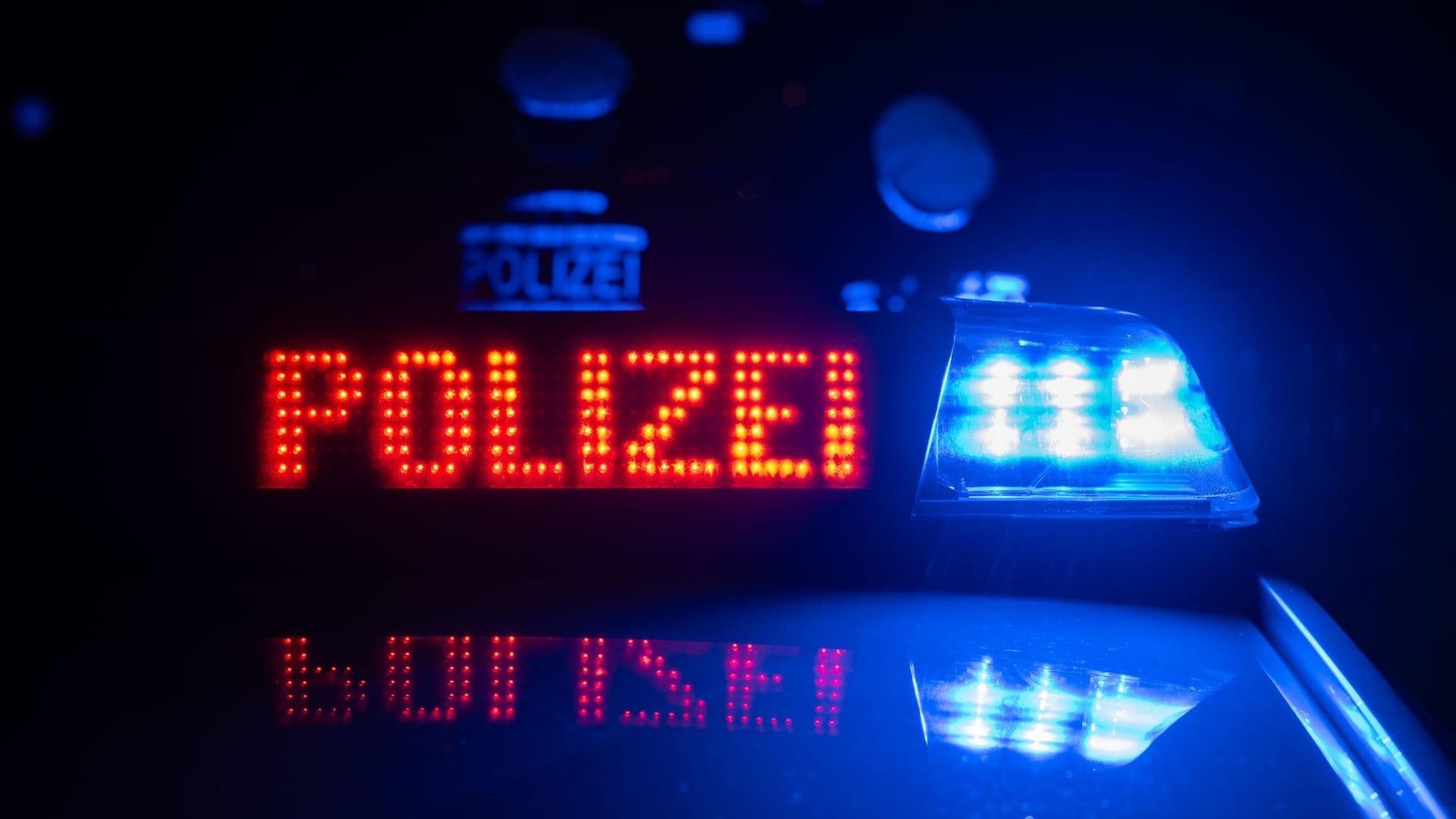 Polizisten vor einem Polizeiauto
