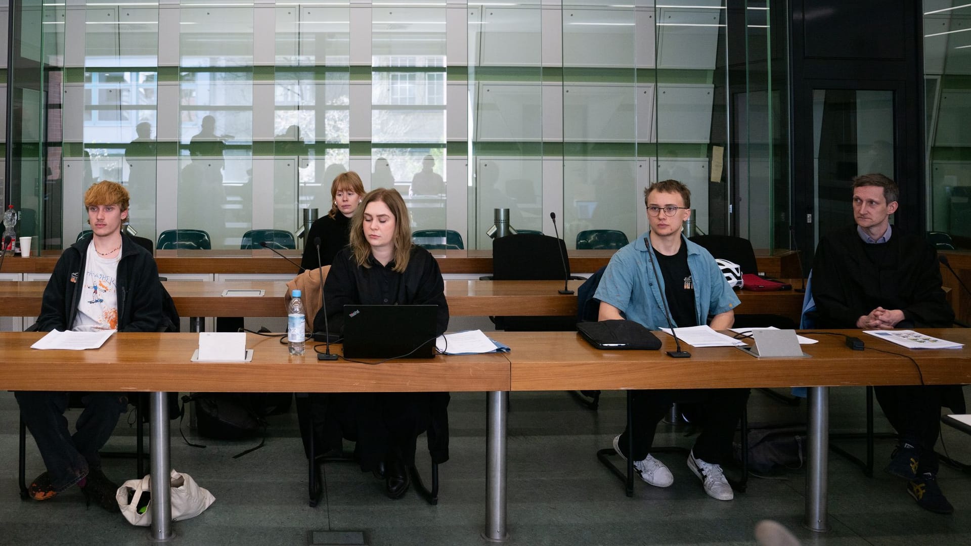 Der Angeklagte Maximilian Hassolt (l), eine Anwältin und der zweite Angeklagte (r, dessen Name nicht genannt wurde): Sie sitzen vor dem Beginn des Prozesses am Kriminalgericht Moabit im Gerichtssaal.