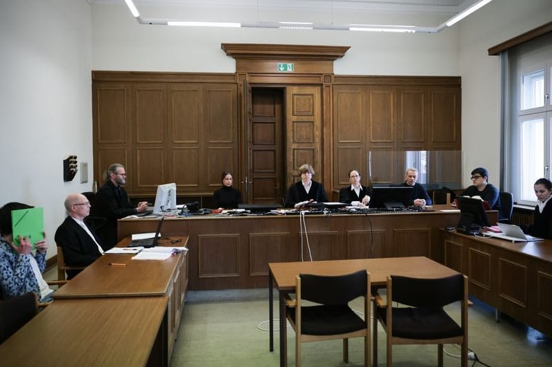 Die Prozessbeteiligten sitzen im Gerichtssaal.