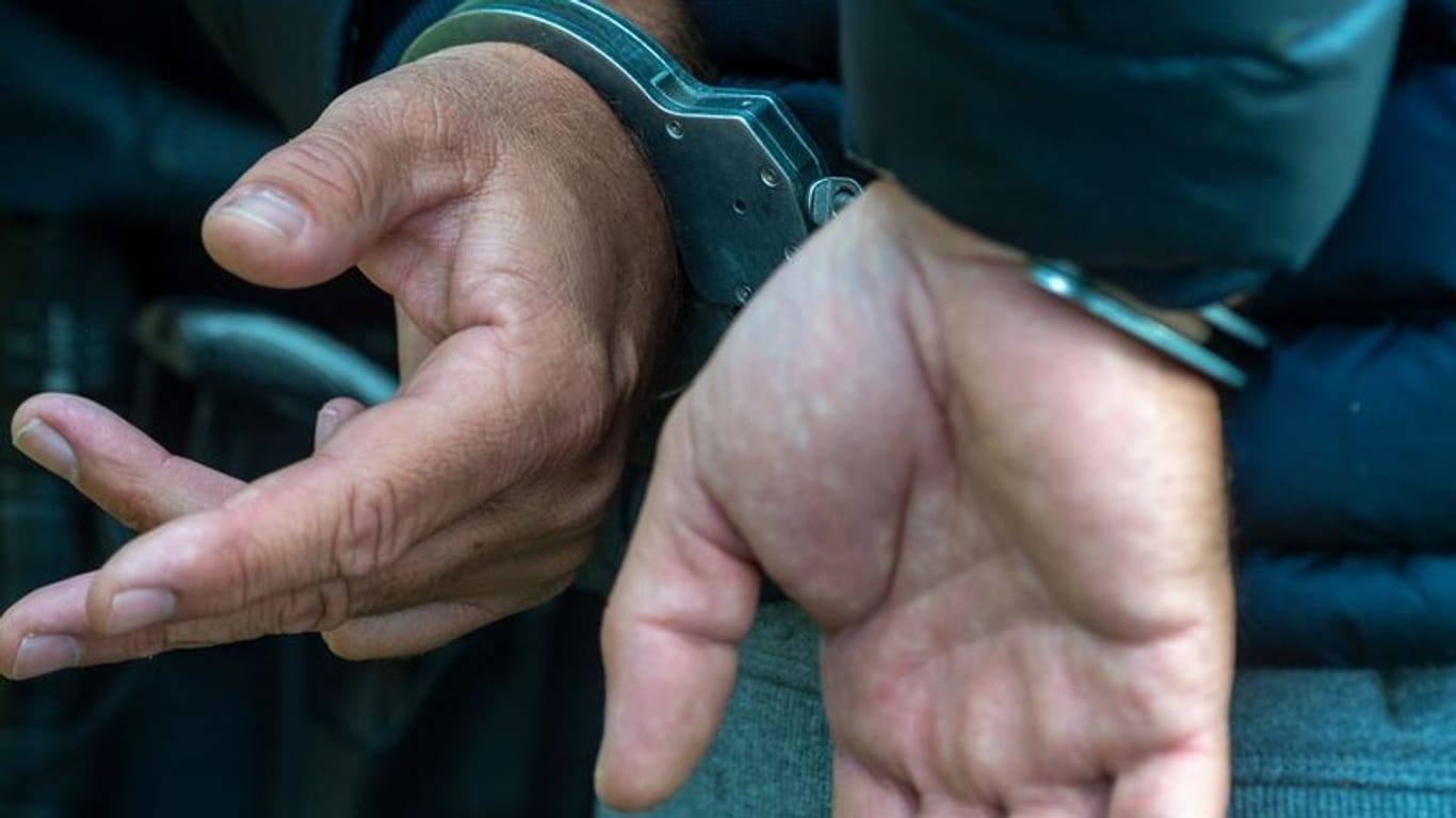 Ein Mann trägt Handschellen (Symbolbild): Ein Häftling ist mit Handschellen aus einer Klinik und wurde wieder gefasst.