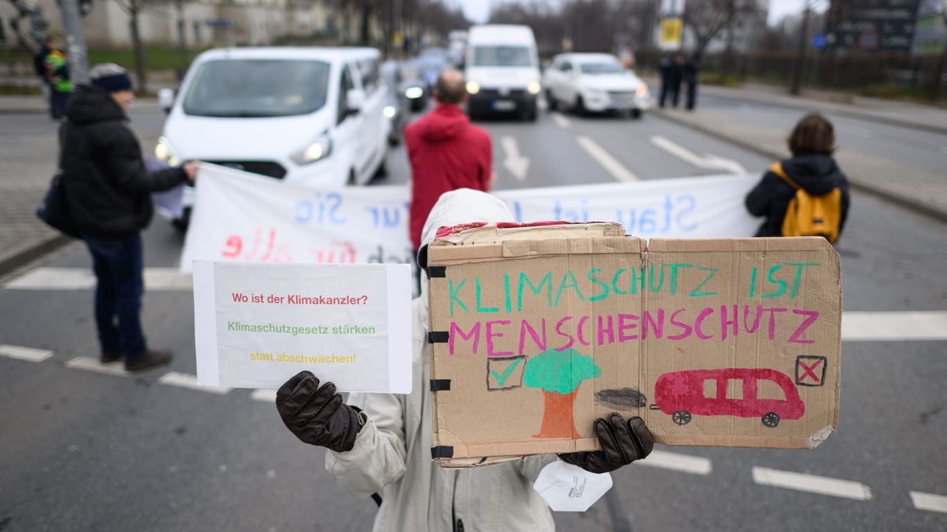 Eine Person hält ein Schild in der Hand: "Klimaschutz ist Menschenschutz"