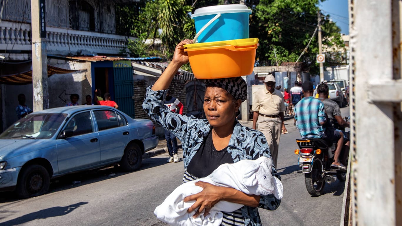 Eine Frau versucht mit ihrem Baby einen Unterschlupf zu finden, während am Freitag in Port-au-Princes die Gewalt eskalierte.