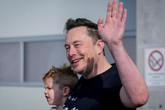 Elon Musk mit seinem Kind vor der Menge in Grünheide: Der Tesla-Chef macht sich vor Ort ein Bild der Lage.
