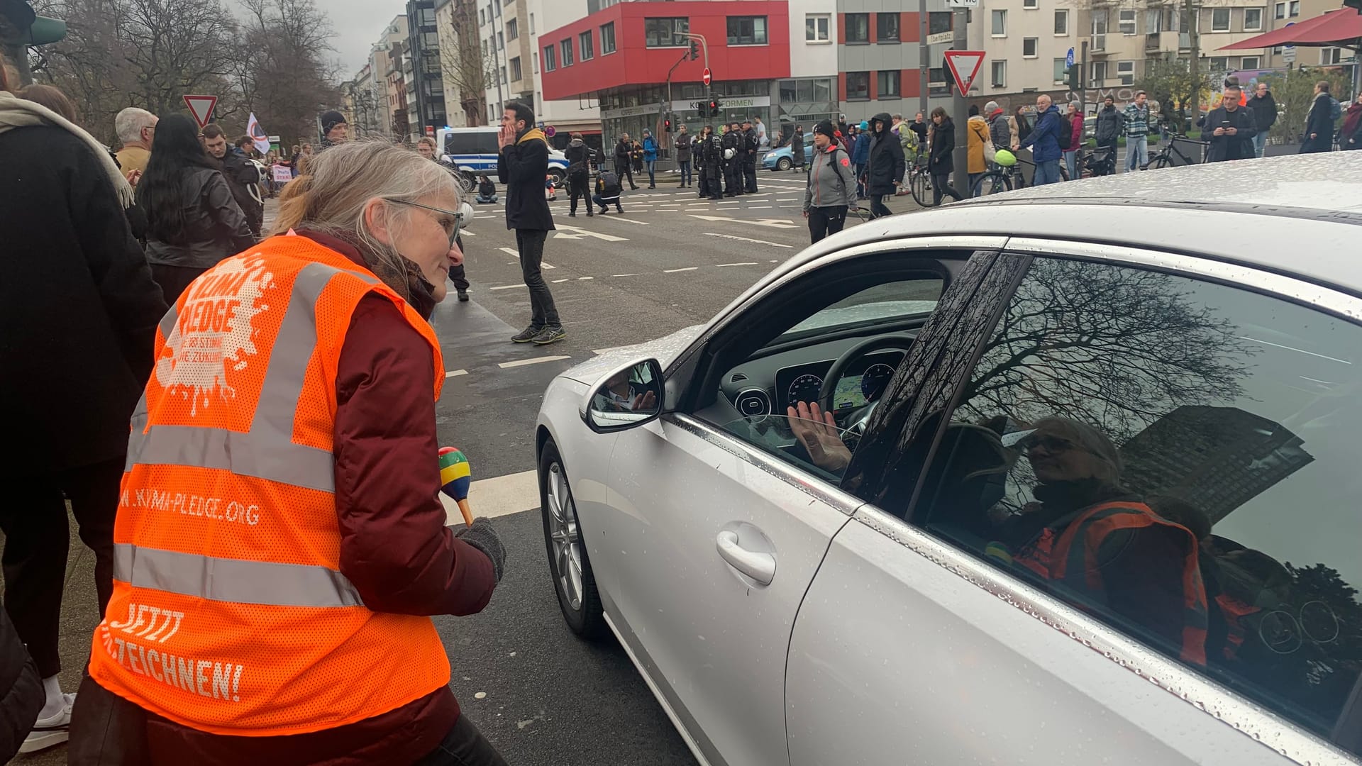 Eine Aktivistin im Gespräch mit einem Autofahrer.