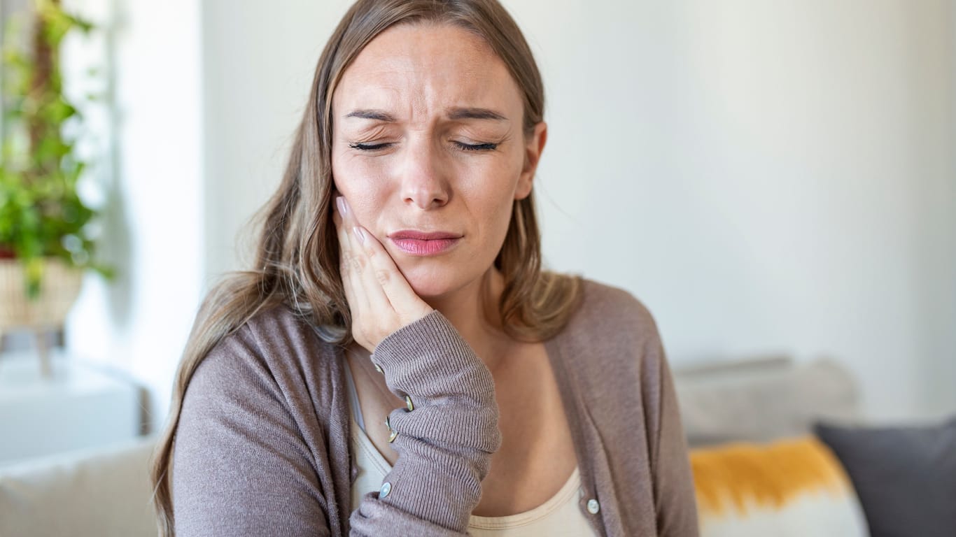 Frau mit Gesichtsschmerzen: Beim Eagle-Syndrom können bestimmte Kopfbewegungen Symptome wie Schmerzen hervorrufen.