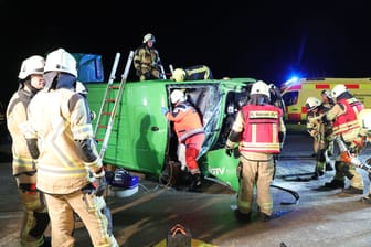 Feuerwehrkräfte sind an dem verunfallten Kleinbus zu Gange: Mehrere Personen wurden in dem Fahrzeug eingeklemmt.