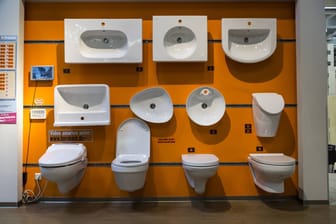 Toilettenschüsseln und Spülbecken hängen zu Ausstellungszwecken in einem Baumarkt (Symbolbild): Ein Reinigungsmitarbeiter musste die widerliche Hinterlassenschaft wegmachen.