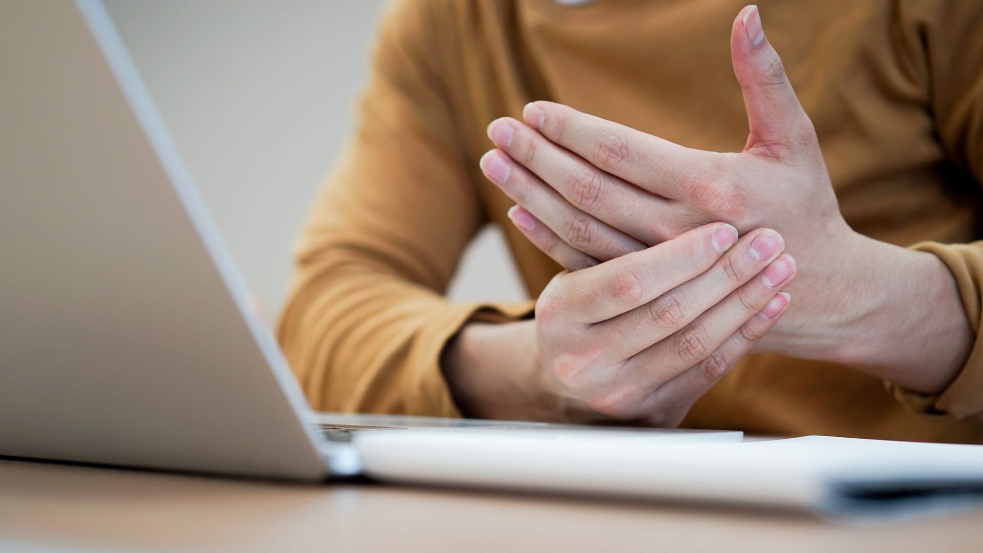 Eine Person hält sich die Hand