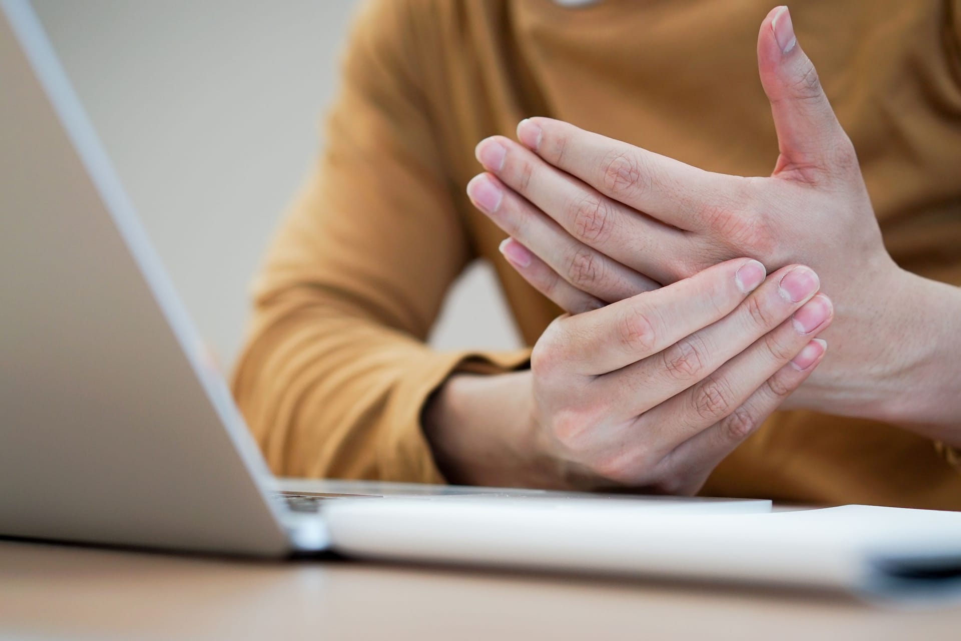 Eine Person hält sich die Hand