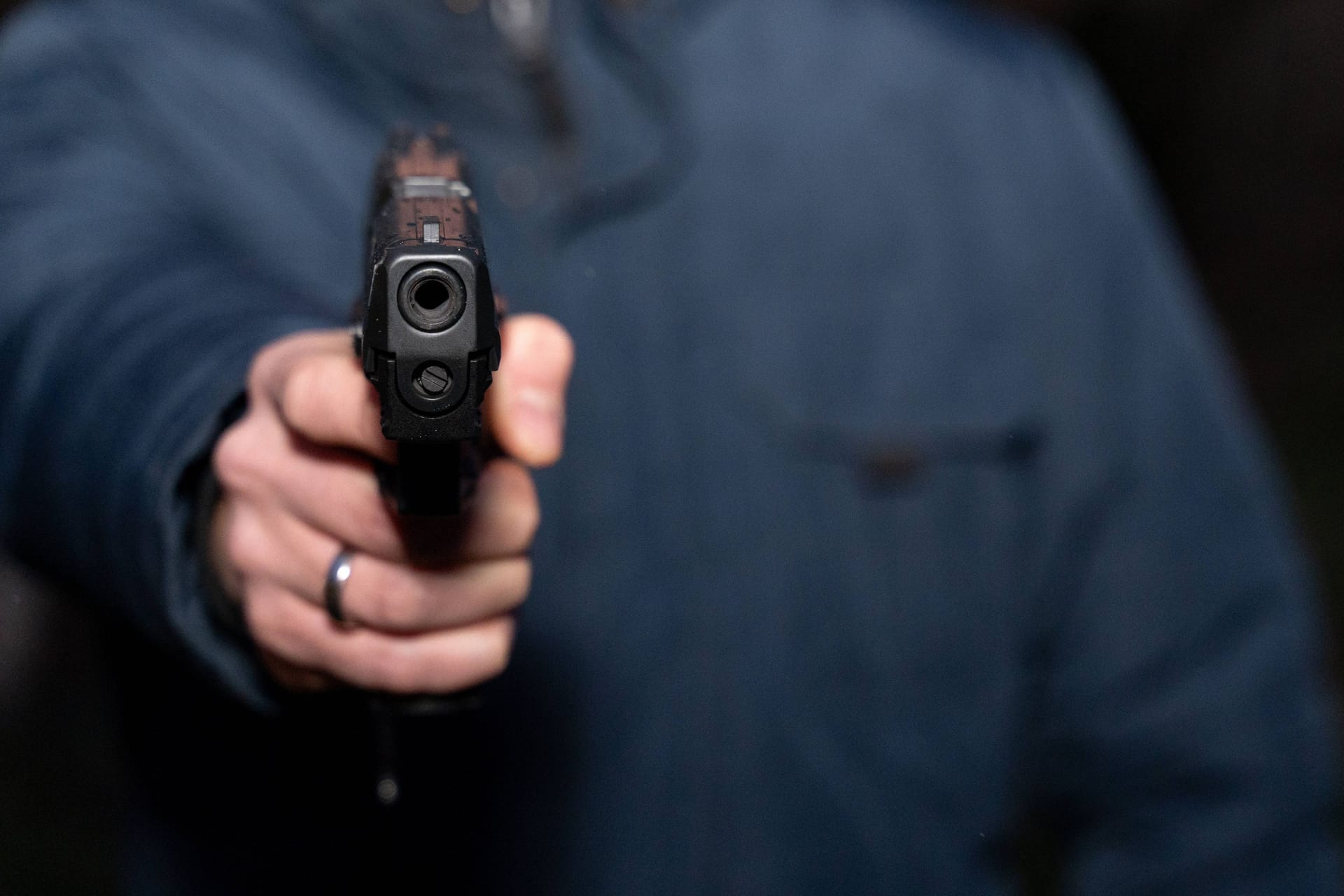 Mann hält eine Pistole (Symbolfoto): In Duisburg sind am Morgen bewaffnete Unbekannte in ein Haus eingebrochen.