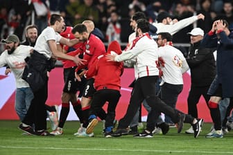 Unbändige Freude: Georgiens Nationalspieler (M.) feiern mit auf den Platz gestürmten Fans.